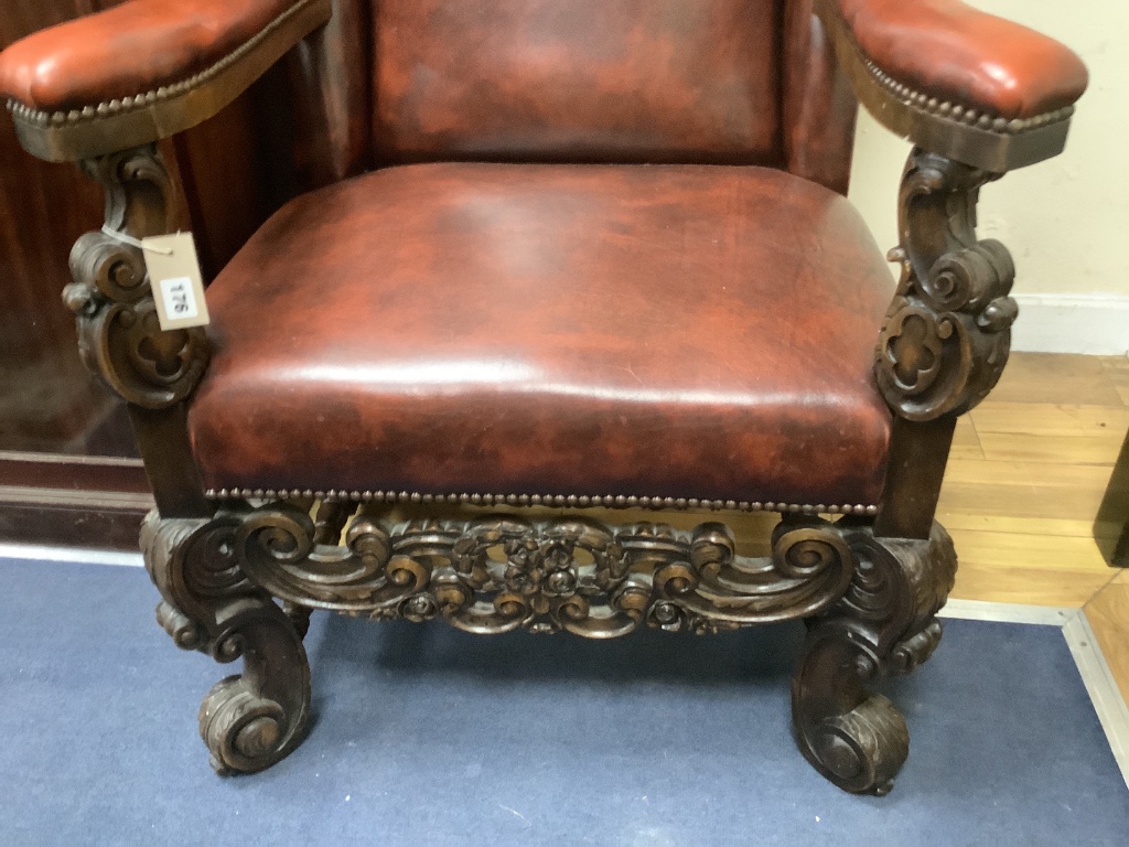 A Carolean style carved walnut and burgundy leather wing armchair, width 72cm, depth 86cm, height 126cm